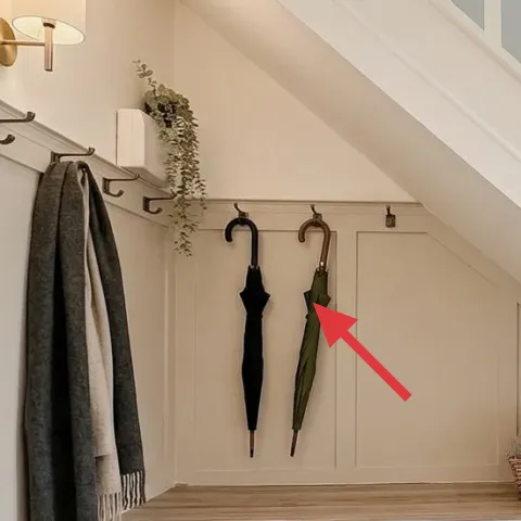 black umbrella hanging on wall hooks