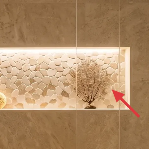 Framed pebble-and-tree print in shower niche