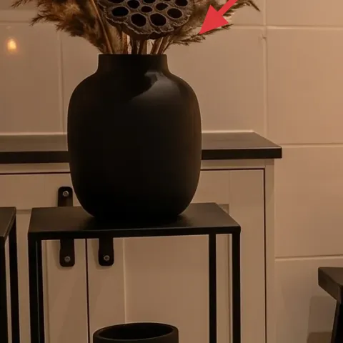 black vase with dried pampas-like stems