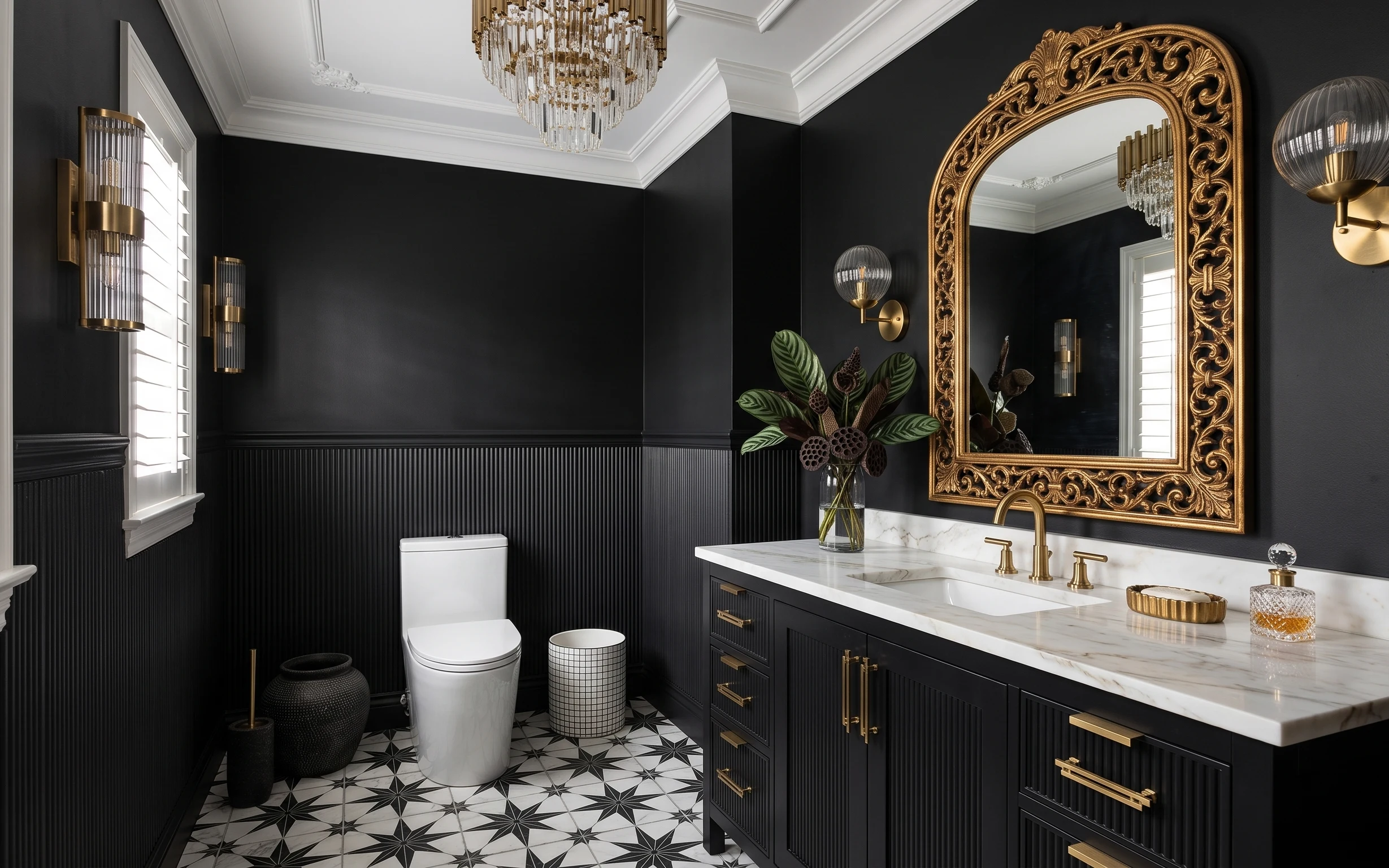 Black paneled bathroom with gold mirror, brass sconces, marble vanity top, toilet, and patterned tile floor